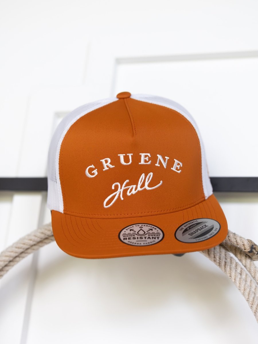 The Savannah Sevens western life{&}style Gruene Hall Cap pairs burnt orange with white mesh and GRUENE Hall embroidered in white script, offering classic trucker style and timeless appeal.