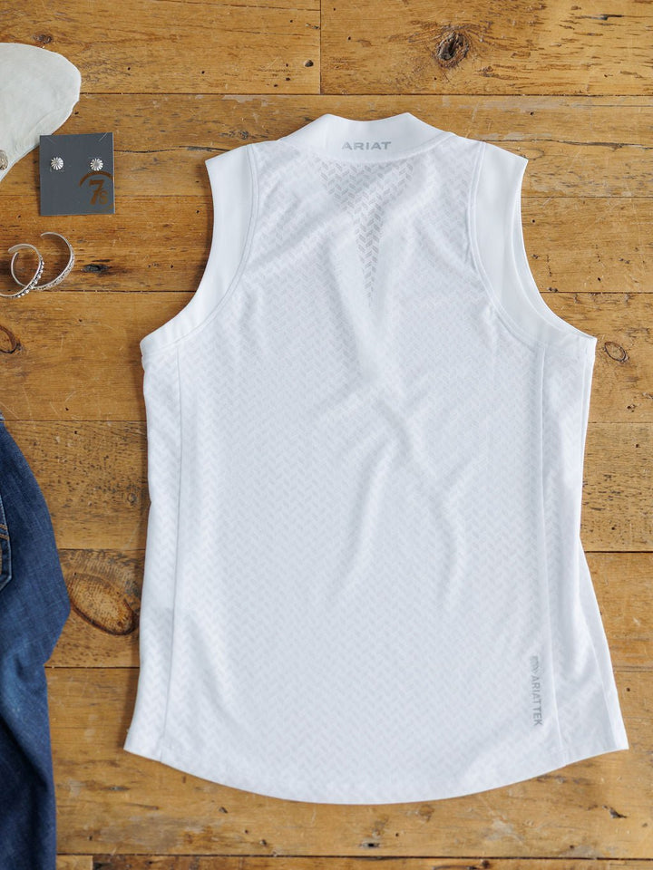 The Hanover Ariat White Golf Tank by Savannah Sevens western life{&}style, featuring subtle patterns and the Ariat logo on the back, is shown with jeans, a bracelet, and earrings. Its breathable mesh fabric ensures lasting comfort.