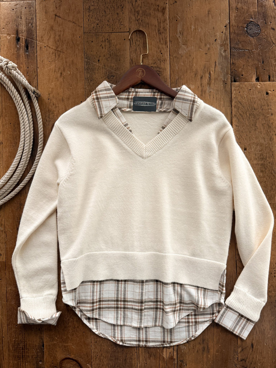 Hollis Cream Layered Plaid Sweater featuring a cream-colored v-neck layered over a tan and brown plaid collared shirt.