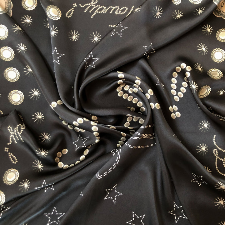The Howdy Wild Rag {Noir} by Savannah Sevens western life{&}style is a black silk scarf with white and gold star, dot, and celestial patterns—perfect as a bold cosmic-inspired western accessory.