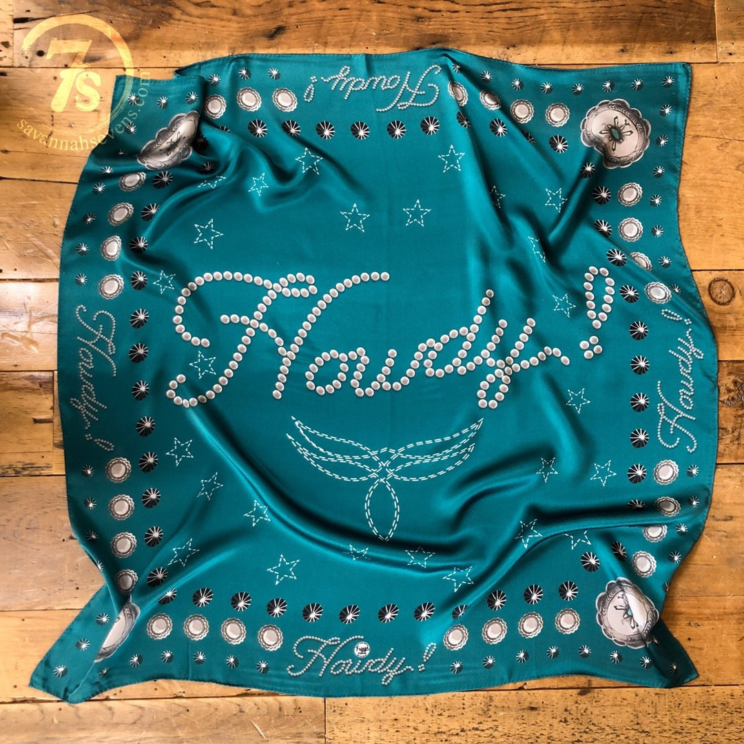 The Howdy Wild Rag {Teal} by Savannah Sevens western life{&}style features "Howdy!" in bold white letters, surrounded by stars, Western motifs, revolvers, and horseshoes. The word "Howdy!" repeats along the edges of this eye-catching accessory.