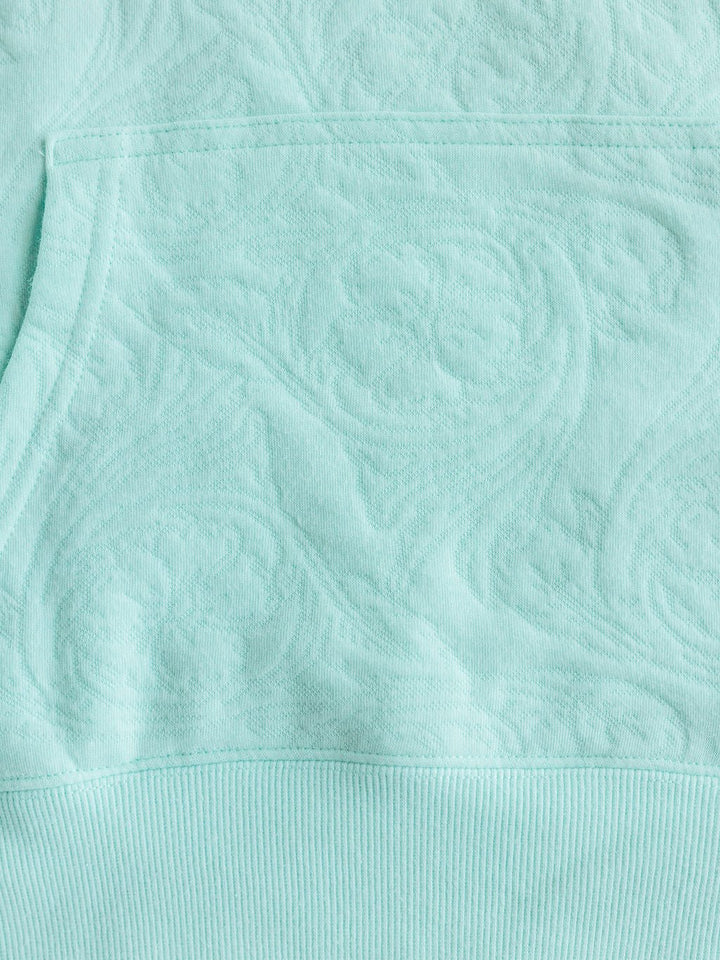 Close-up of The Hoyt hoodie by Savannah Sevens western life{&}style (S-XXL) in light turquoise cotton blend, featuring a subtle raised floral & swirl pattern, ribbed hem, and highlighted pocket for stylish comfort.