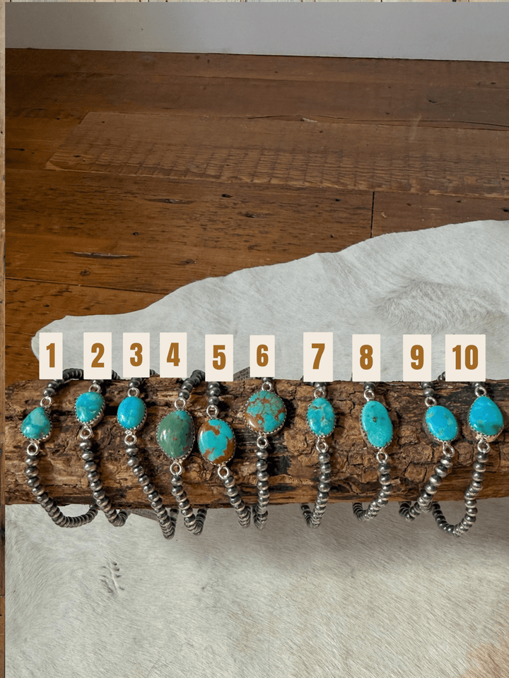 Ten turquoise and sterling Navajo pearl Kemah Turquoise Stone bracelets by Savannah Sevens western life&style, arranged in a row and numbered one through ten.