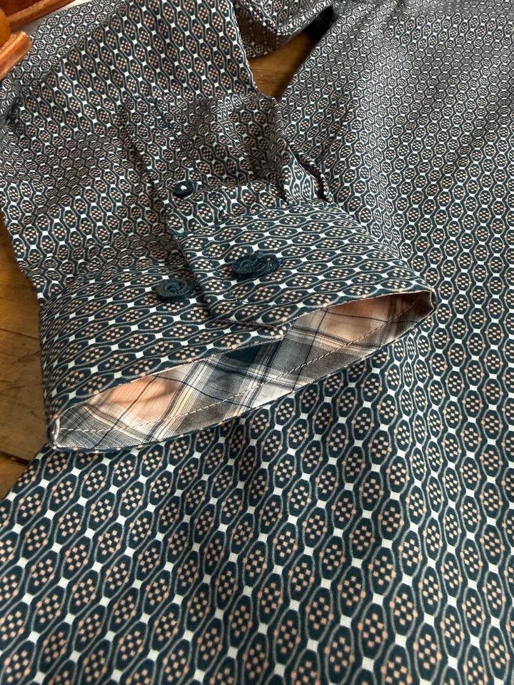 Close-up of the Kenton Cinch Men’s Southwest Button Up by Savannah Sevens western life{&}style, showcasing two visible cuffs; the outer fabric displays a blue and beige southwest pattern, while the inside of the cuff features a blue, beige, and white plaid design.