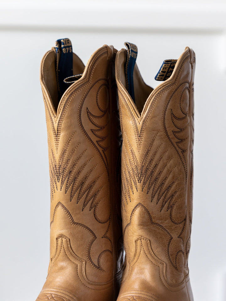 A close-up of The Leawood Boot {Honey} by Savannah Sevens western life{&}style, featuring light brown leather with dark brown stitching and a Western cutter toe design, set against a plain white background.
