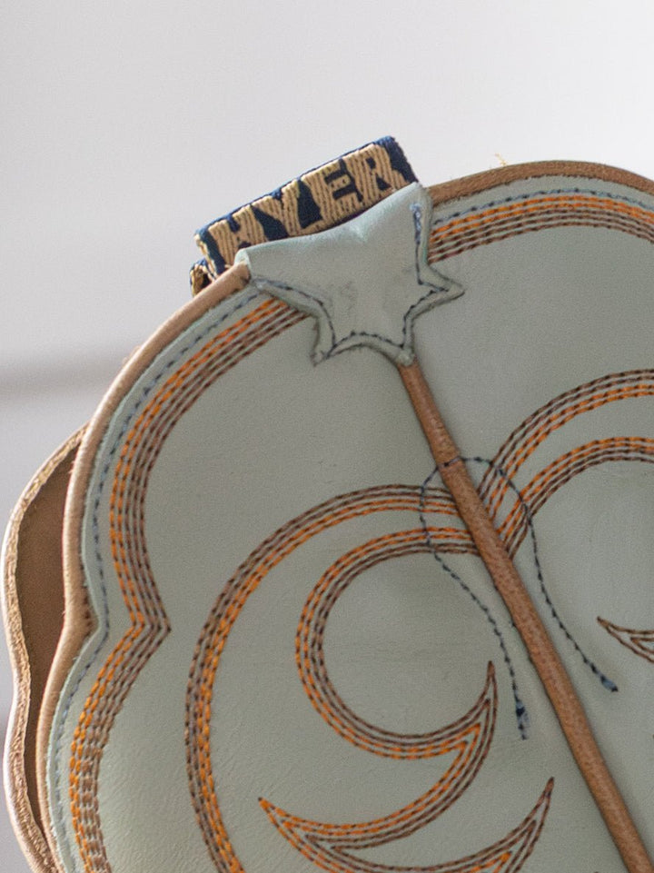 Close-up of a light-colored leather baseball glove with orange stitching, echoing the craftsmanship of Savannah Sevens western life{&}style’s The Hyer Leawood Boot {Robin's Egg}. 