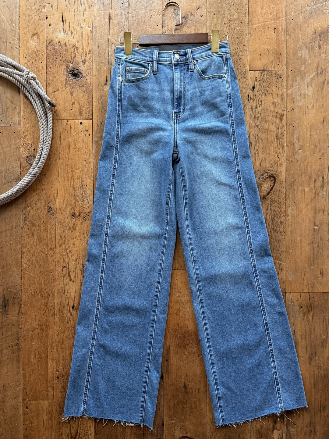 Liam High Rise Wide Leg Jean by Savannah Sevens western life&style in a medium wash featuring vertical front seams and raw-edge hems.
