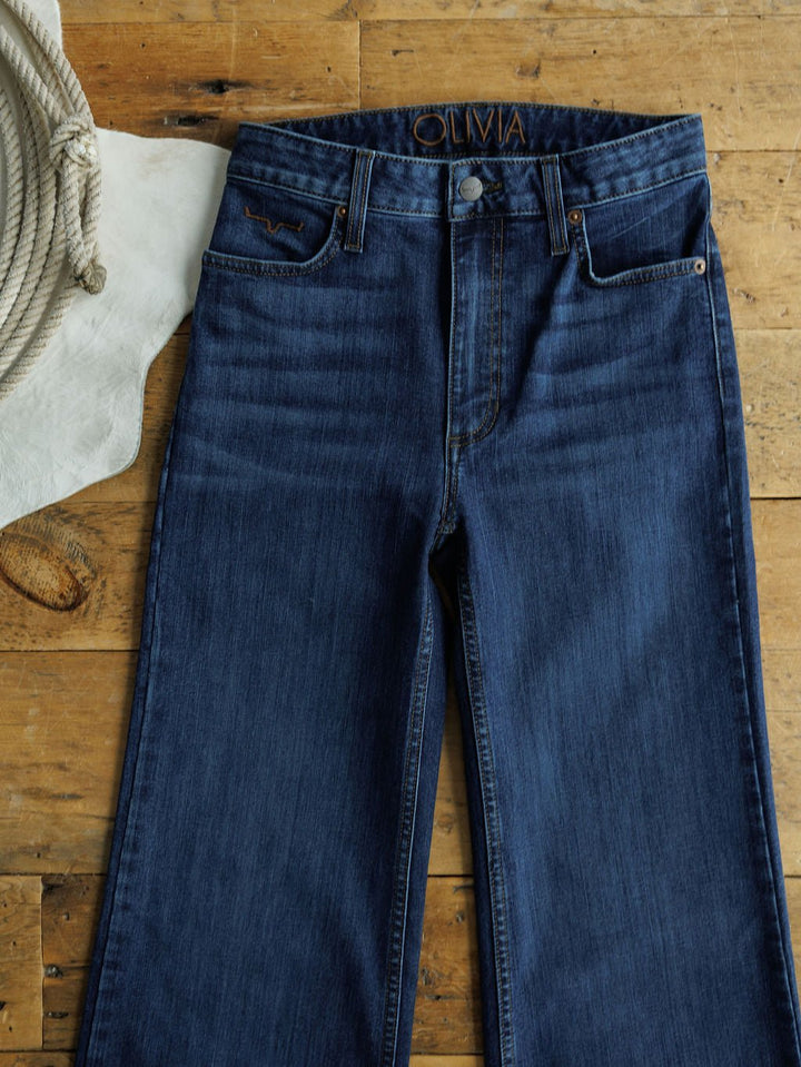 The Livy High Rise 90's Wide Leg Jean *Exclusive* from Savannah Sevens western life{&}style is laid flat on a rustic wooden surface with a coiled rope and white fabric or hide on the left.