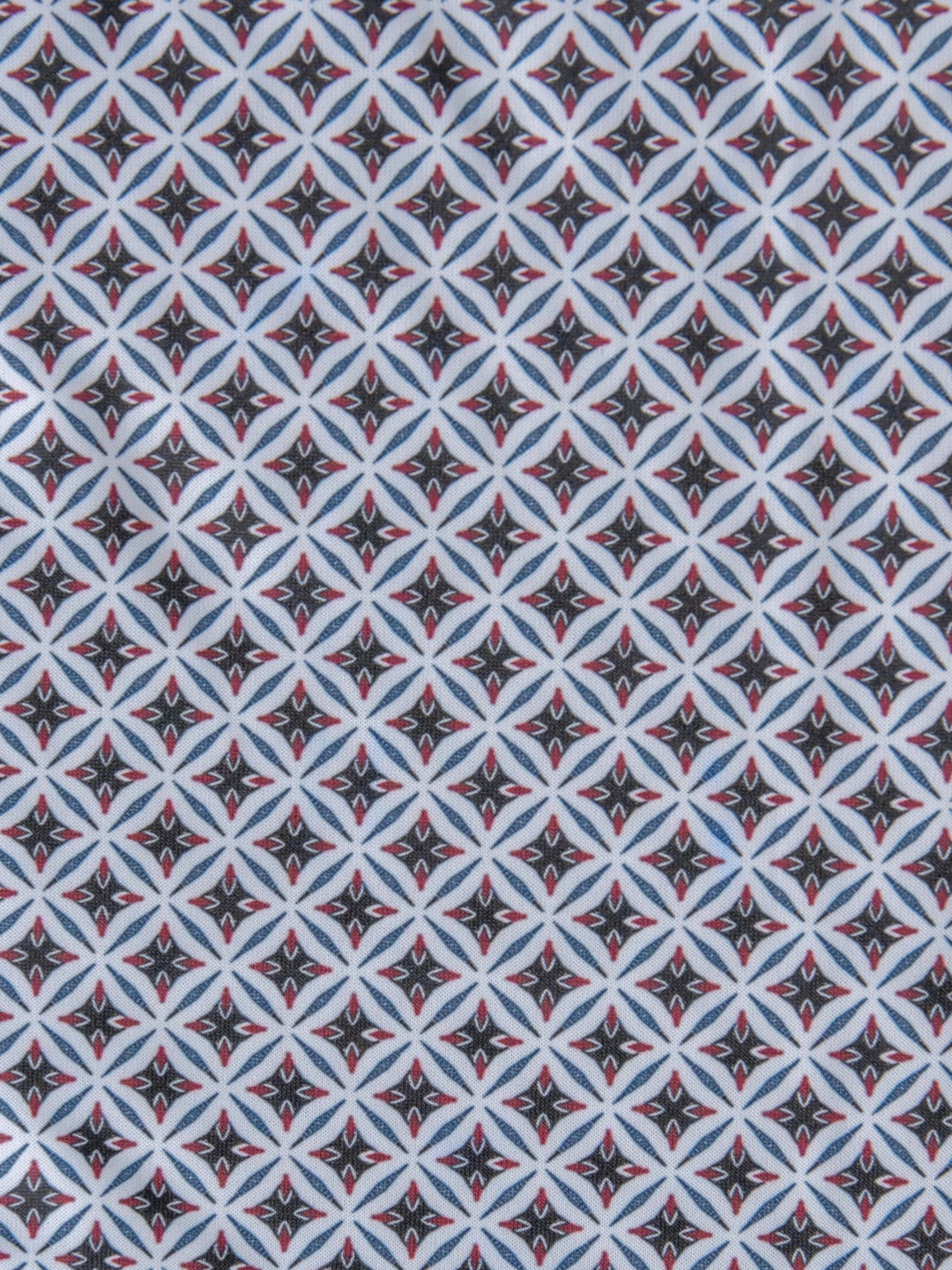 A repeating geometric pattern with diamond shapes in black, white, light blue, and red accents—perfect for the Lyman Ariat Men's Southwest Polo by Savannah Sevens western life{&}style.