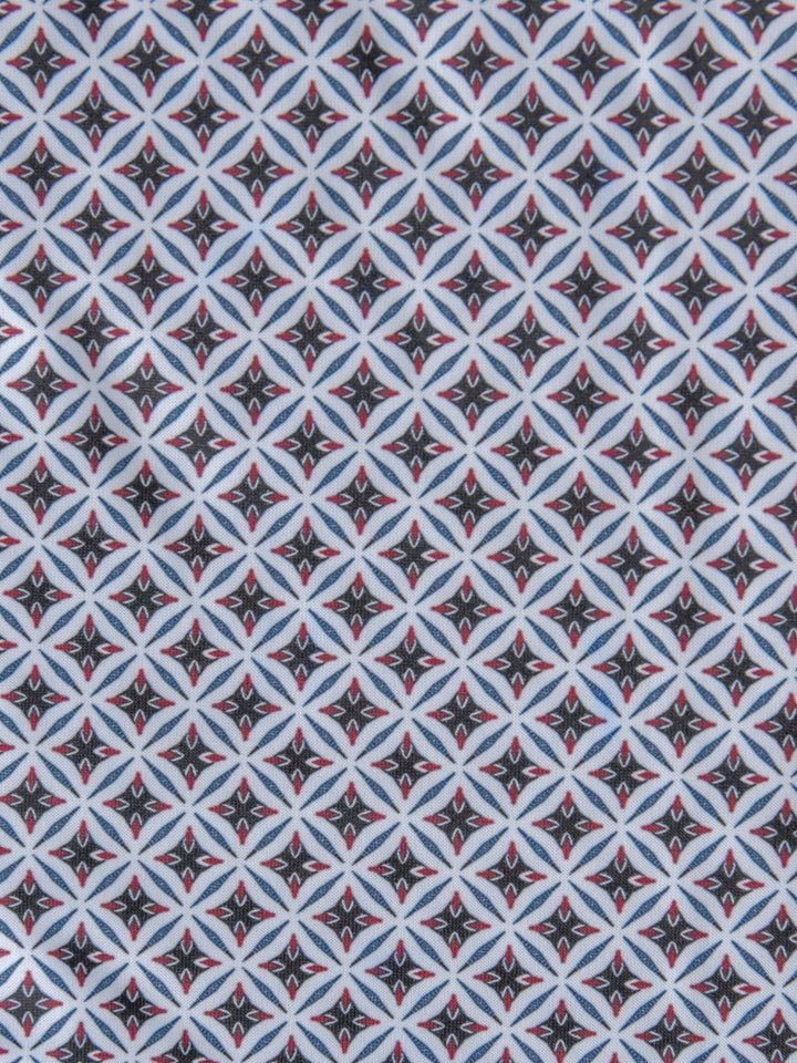 A repeating geometric pattern with diamond shapes in black, white, light blue, and red accents—perfect for the Lyman Ariat Men's Southwest Polo by Savannah Sevens western life{&}style.
