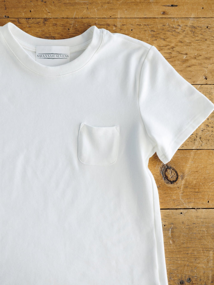 White t-shirt with a pocket on a wooden surface