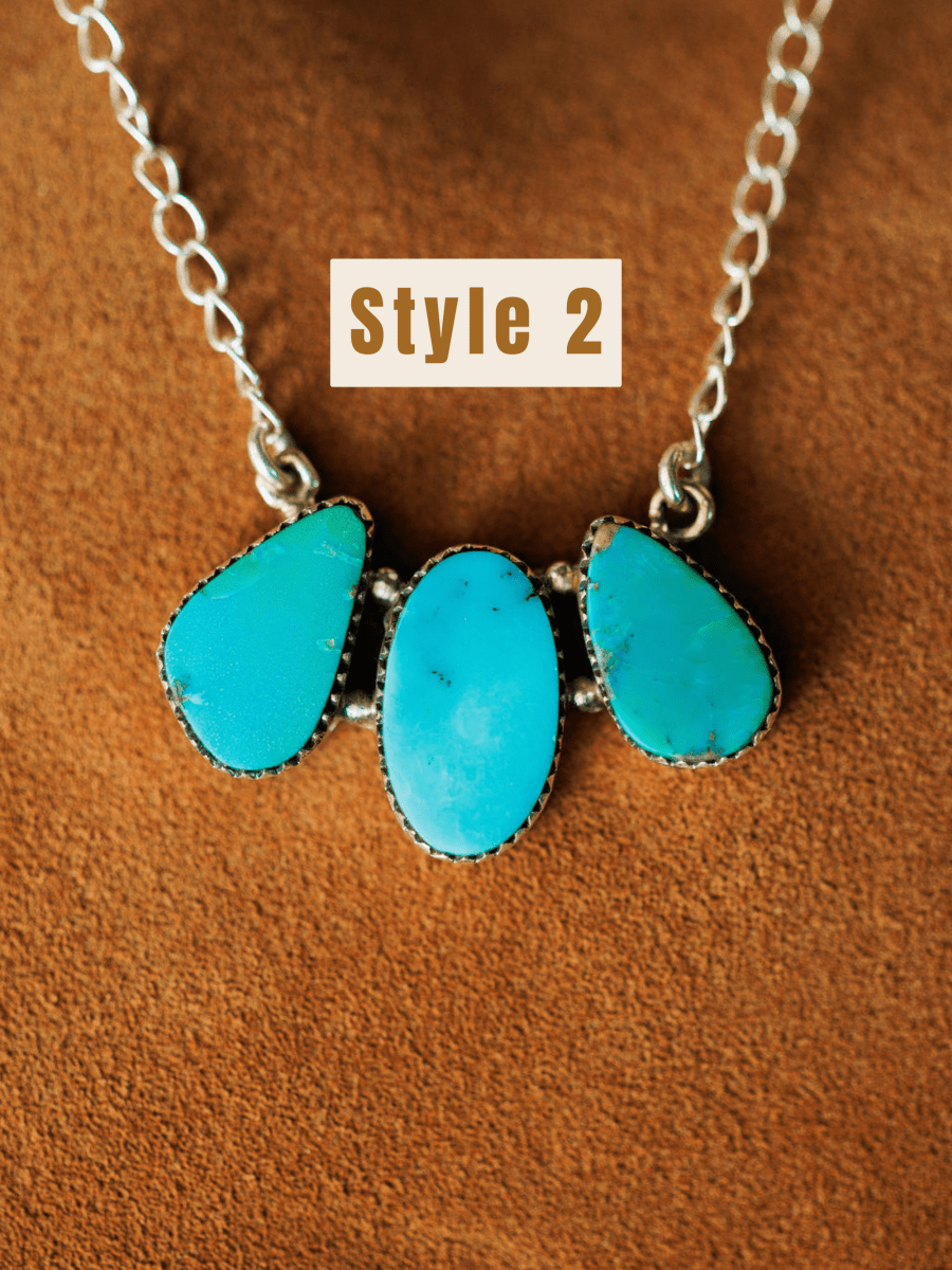 The Montrose Necklace by Savannah Sevens western life{&}style features three turquoise stones—two teardrop-shaped and one oval—set in sterling silver, shown on a brown background with "Style 2" above the necklace.