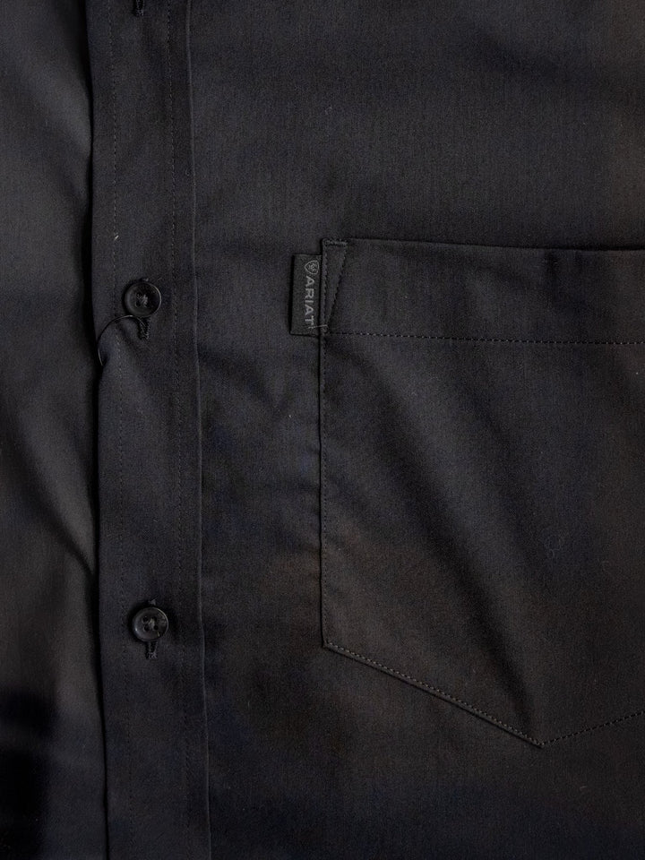 Close-up of the Newnan Ariat Men's Black Button Up by Savannah Sevens western life{&}style, showcasing two buttons, precise stitching, a chest pocket with fabric tag, and a wrinkle-resistant finish for style and durability.