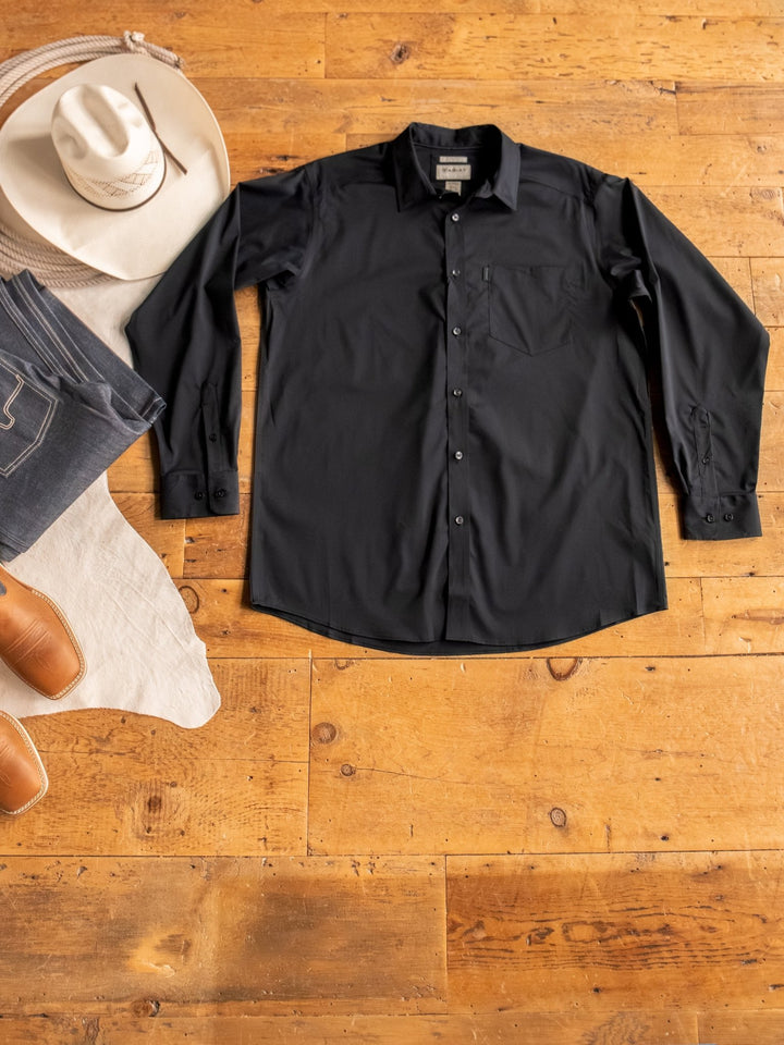 The Newnan Ariat Men's Black Button Up from Savannah Sevens western life{&}style is laid flat on a wooden floor, surrounded by a white cowboy hat, blue jeans, tan boots, and a light-colored garment. Wrinkle-resistant and perfect for any stylish outfit.