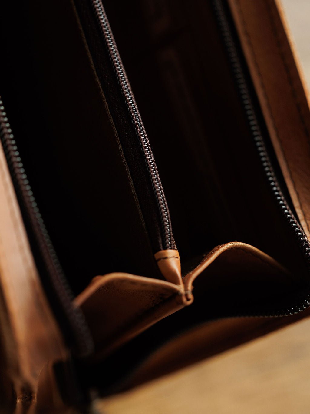 Close-up of an empty Nocona Leather Crossbody Wallet by Savannah Sevens western life{&}style, made from brown full grain leather with open compartments and a visible zipper; no cash or cards inside.