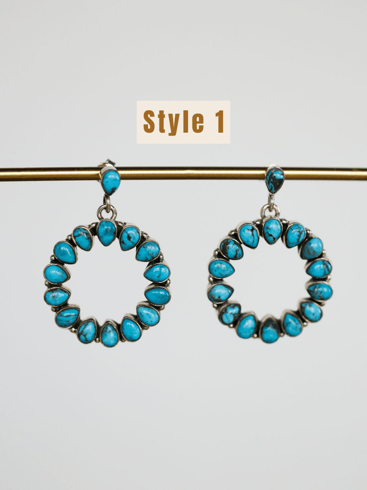 The Ocala Earrings by Savannah Sevens western life{&}style feature small Kingman turquoise stones set in sterling silver, hanging from a gold rod. A beige label above reads Style 1.