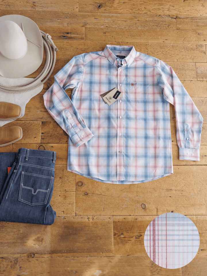 The Palmer Ariat Men's Plaid Button Up by Savannah Sevens western life{&}style is showcased in light blue, pink, and white plaid, laid flat with jeans, cowboy hat, and boots. A close-up highlights its moisture-wicking fabric pattern.
