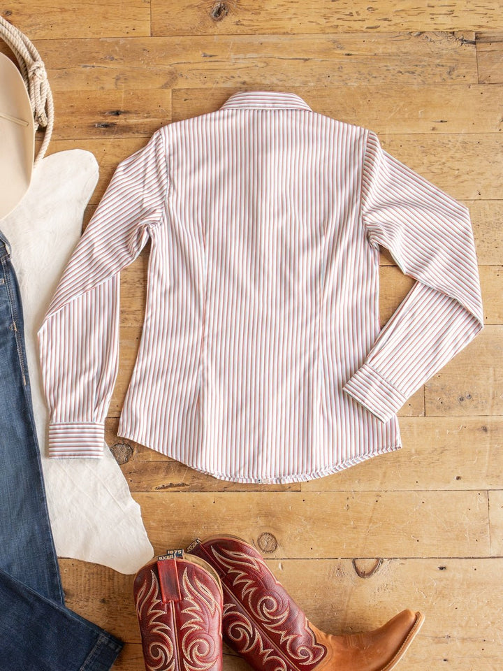 The Patton Striped Tencel Performance Shirt by Savannah Sevens western life{&}style is laid flat on a wooden floor next to a pair of red cowboy boots, a white cloth, jeans, and a beige hat.