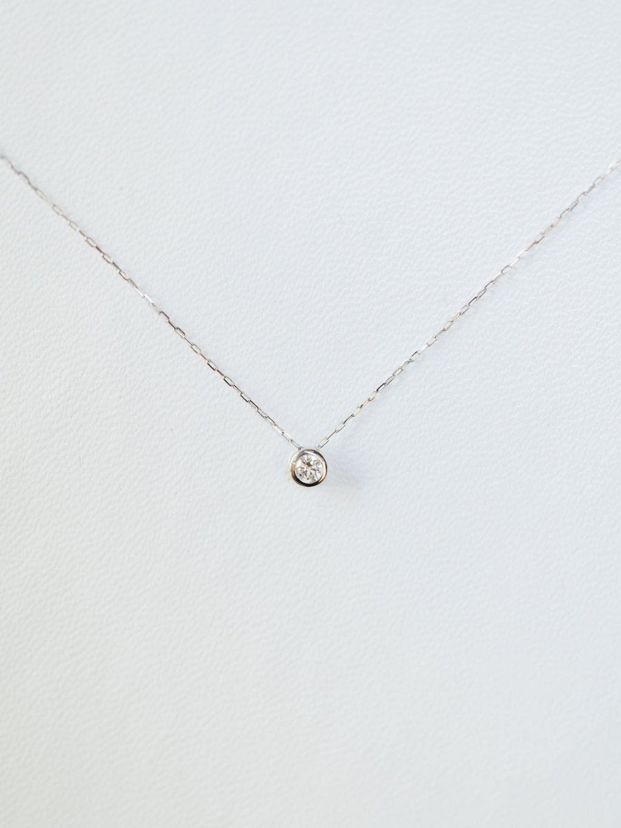The Petite Diamond Necklace {White Gold} by Savannah Sevens western life{&}style features a natural round diamond solitaire in a simple bezel, crafted in 18K white gold and shown on a plain white background.