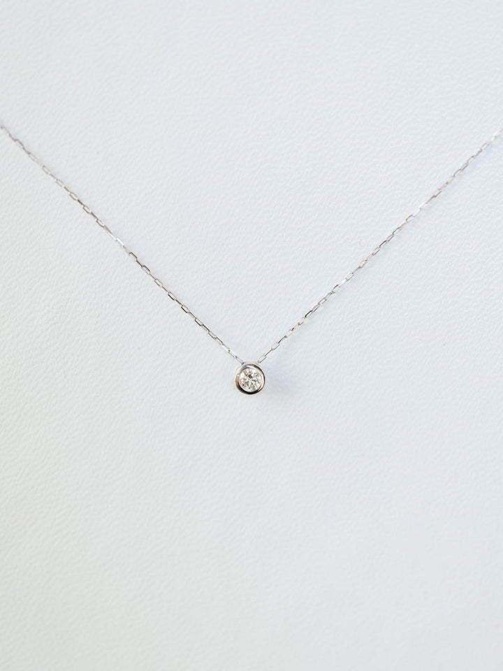 The Petite Diamond Necklace {White Gold} by Savannah Sevens western life{&}style features a natural round diamond solitaire in a simple bezel, crafted in 18K white gold and shown on a plain white background.