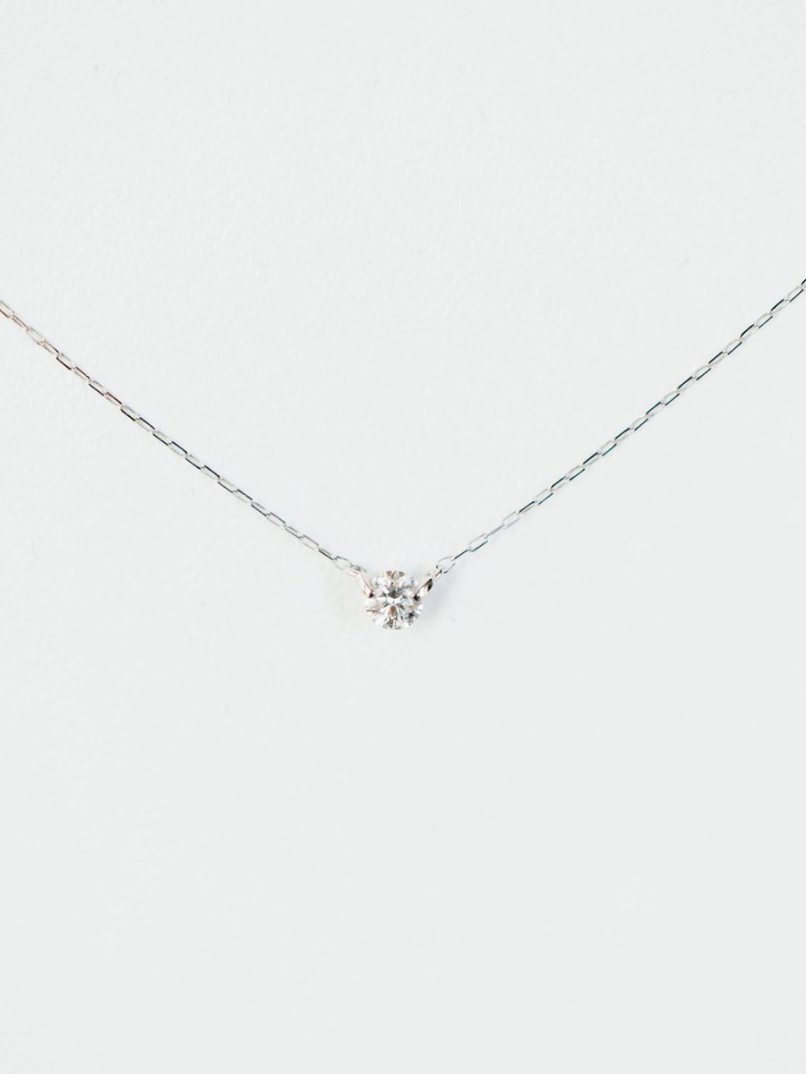 The Petite Diamond Necklace {White Gold} by Savannah Sevens western life{&}style features a delicate 18K white gold chain with a small natural round diamond pendant, displayed against a plain white background.