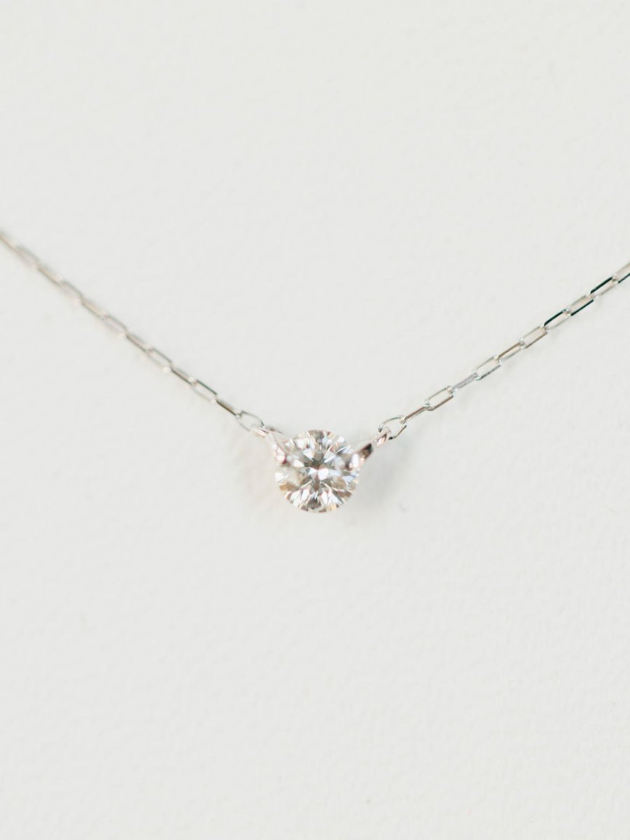 The Savannah Sevens western life{&}style Petite Diamond Necklace {White Gold} features a natural round solitaire diamond pendant set in 18K white gold, elegantly displayed against a white background.