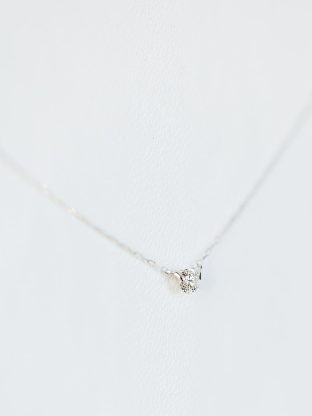 The Petite Diamond Necklace {White Gold} by Savannah Sevens western life{&}style features a single natural round diamond pendant in 18K white gold, displayed against a white background.