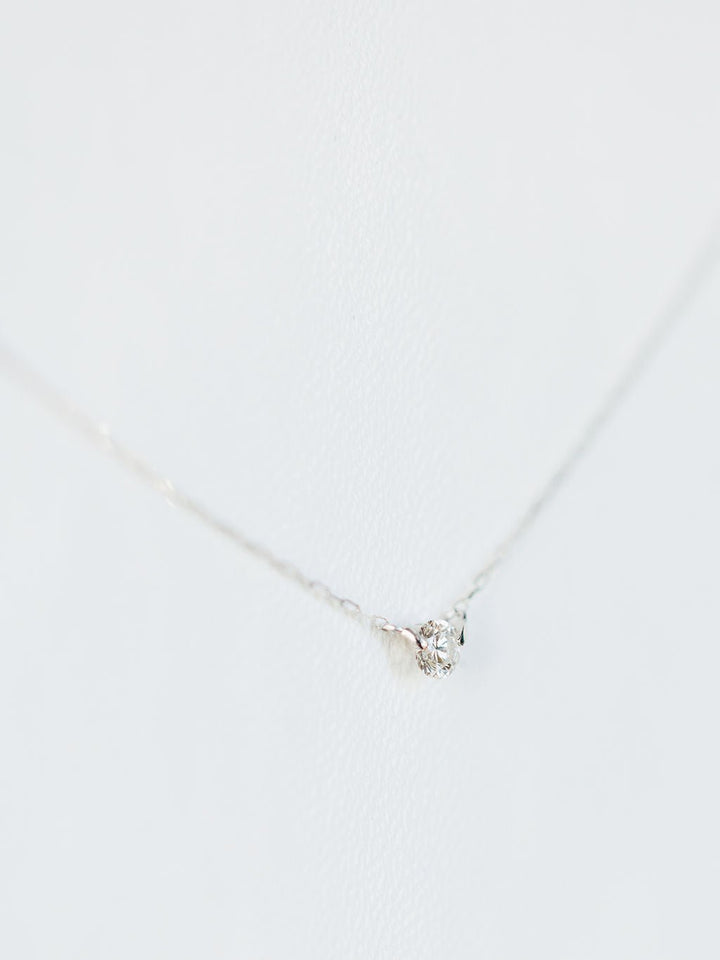 The Petite Diamond Necklace {White Gold} by Savannah Sevens western life{&}style features a single natural round diamond pendant in 18K white gold, displayed against a white background.