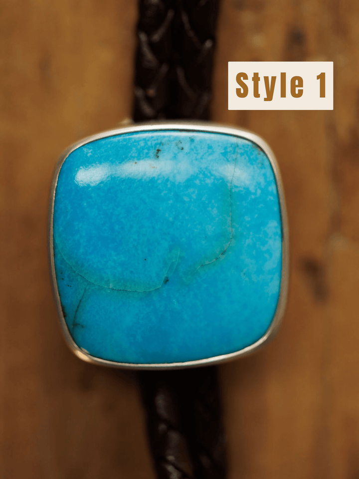 A close-up shows the Peyote Bolo by Savannah Sevens western life{&}style: a turquoise bolo tie with a rectangular stone featuring thin cracks, set in silver on a dark braided band. The background is brown wood, with "Style 1" labeled at the top right.