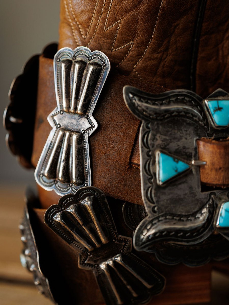 Close-up of Portales Belt by Savannah Sevens western life{&}style, a brown leather cowboy boot accessory adorned with vintage sterling silver and #8 Turquoise concho belt, featuring intricate engraved patterns.