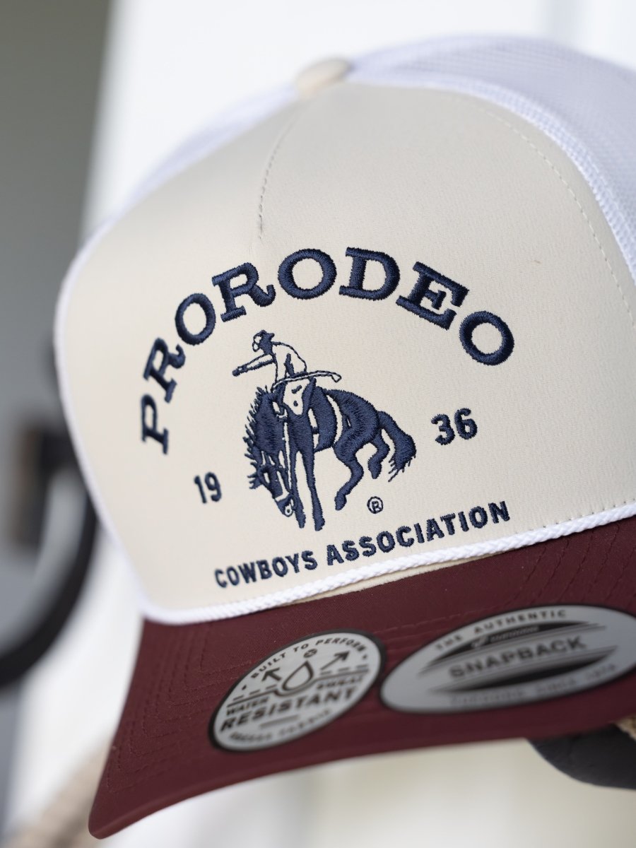 The PRCA Cap by Savannah Sevens western life{&}style is a water- and sweat-resistant trucker cap featuring an embroidered cowboy on a bucking horse.