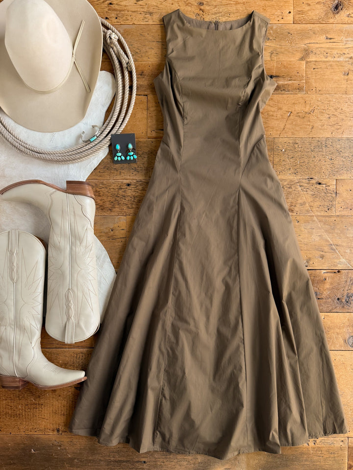 The Ralston Mushroom Sleeveless Dress by Savannah Sevens western life{&}style is laid out with white cowboy boots, a beige cowgirl hat, turquoise earrings, and a white cowhide, all arranged on a wooden floor.