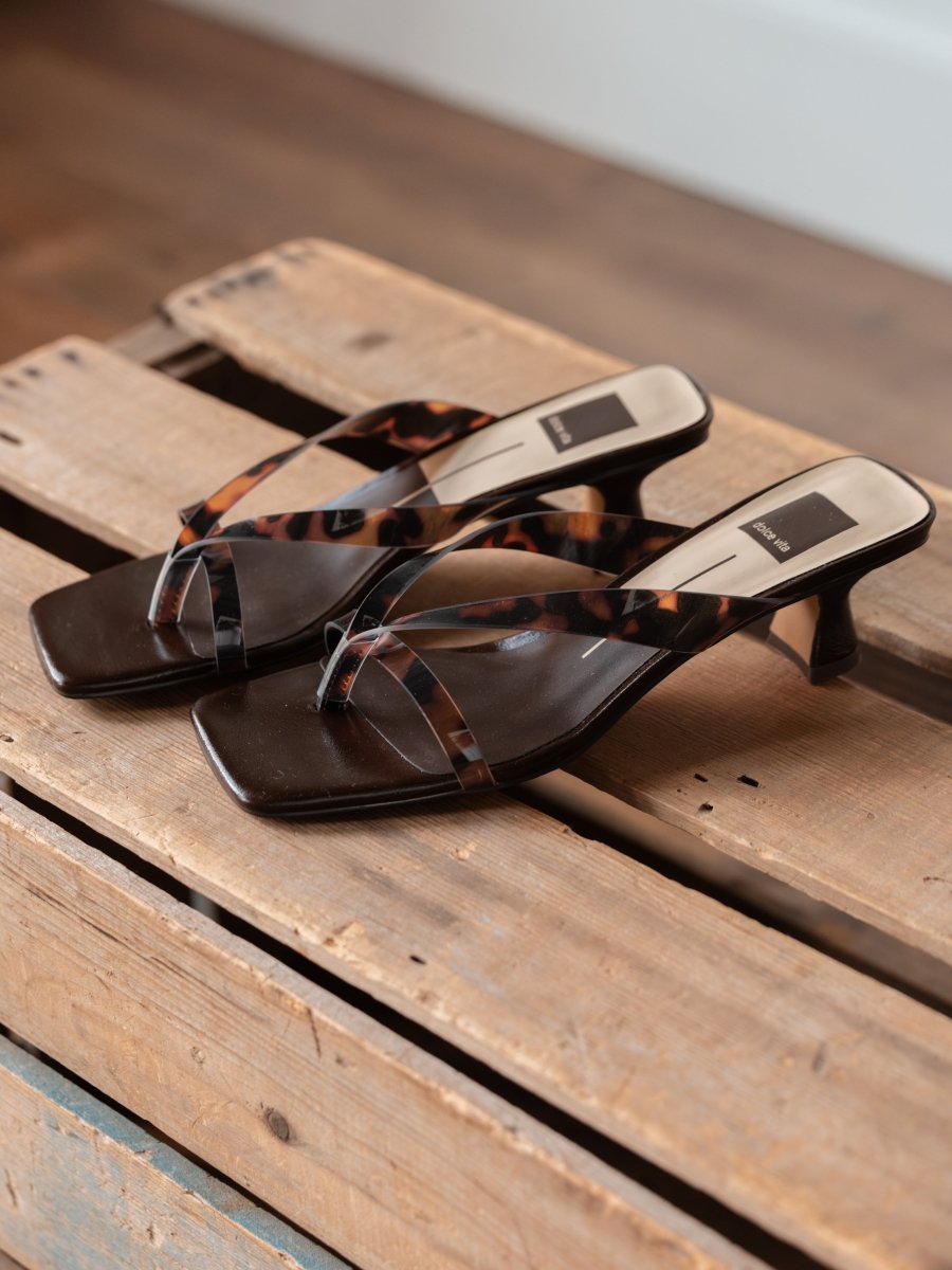 The Roslyn by Savannah Sevens western life{&}style: brown multi-strap heeled sandals with tortoiseshell-patterned straps and a square toe, displayed on a rustic wooden pallet.