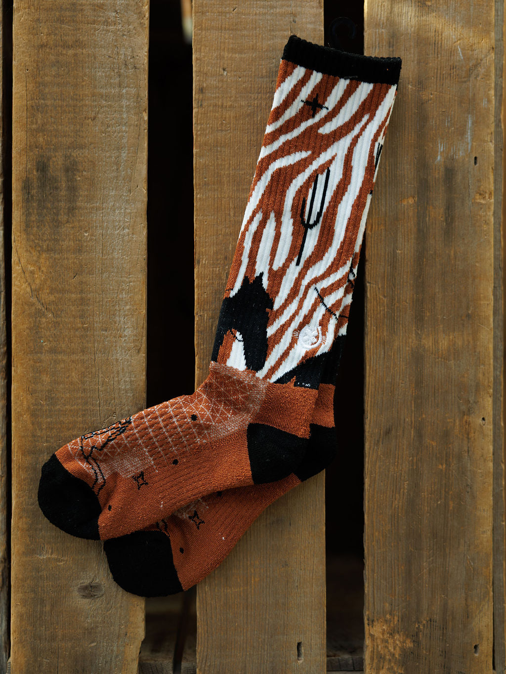 The Maverick Crew Socks by Savannah Sevens western life{&}style feature bold orange, black, and white zebra stripes with black toes and heels, offering odor-fighting comfort and standout style for your everyday wardrobe.