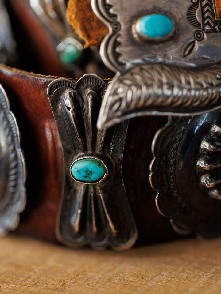 Close-up of the New Mexico Belt by Savannah Sevens western life{&}style, featuring ornate sterling silver and turquoise details with intricate metalwork and striking blue-green accents.