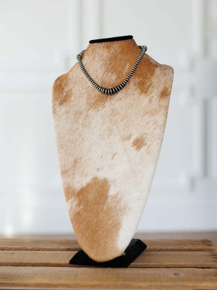 Sarita Graduated Navajo Pearl Necklace in sterling silver displayed on a cowhide-patterned jewelry bust.