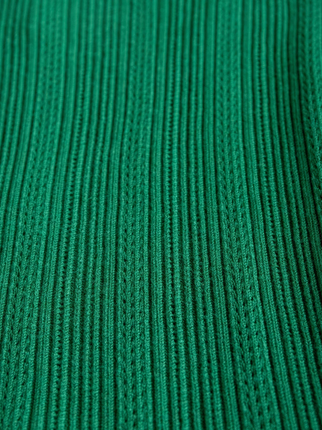 Close-up of the Sebring Emerald Flutter Sleeve Top by Savannah Sevens western life{&}style, highlighting its ribbed knit fabric, vertical textured stripes, and detailed stitching.