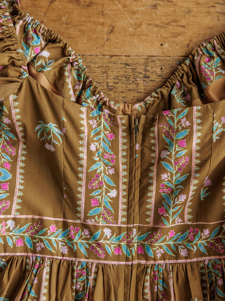 The Senoia Floral Puff Sleeve Dress by Savannah Sevens western life{&}style features a brown cotton floral print bodice with a zipper closure.
