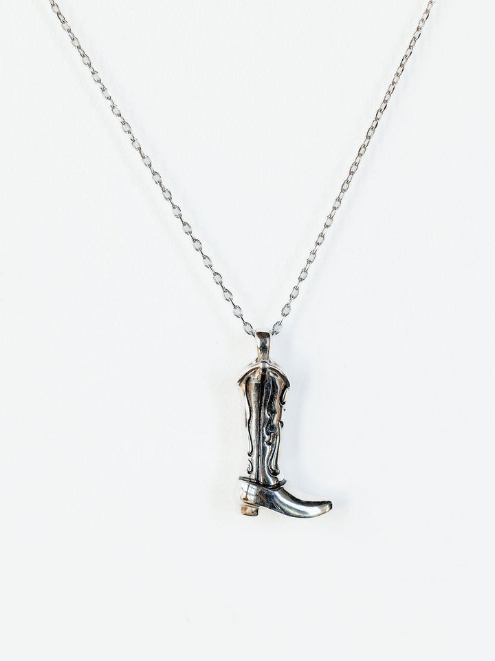 The Silver Cowgirl Boot Necklace by Savannah Sevens western life{&}style features a detailed pendant, beautifully displayed against a white background.