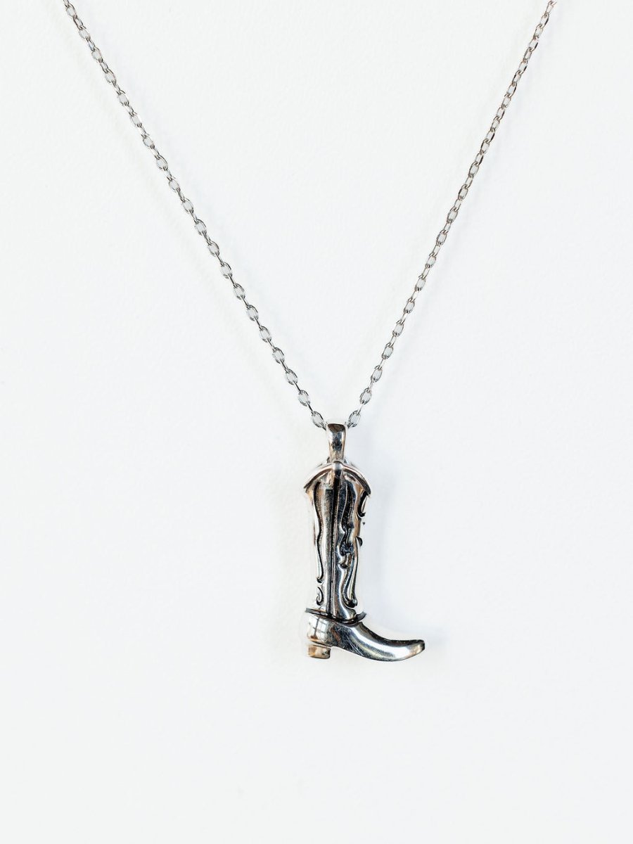 The Silver Cowgirl Boot Necklace by Savannah Sevens western life{&}style features a detailed pendant, beautifully displayed against a white background.