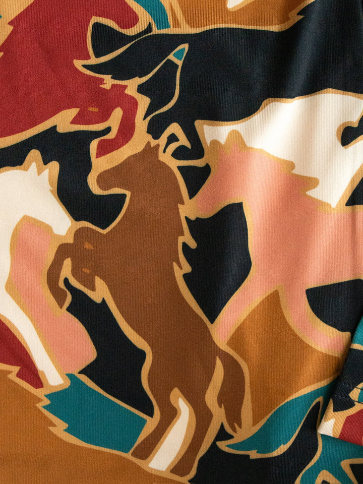 The Socorro Western Graphic Top by Savannah Sevens western life{&}style showcases an abstract pattern of overlapping horse silhouettes in brown, black, white, and tan on a vibrant multicolored fabric background—perfect for anyone seeking a unique horse print or standout western graphic top.