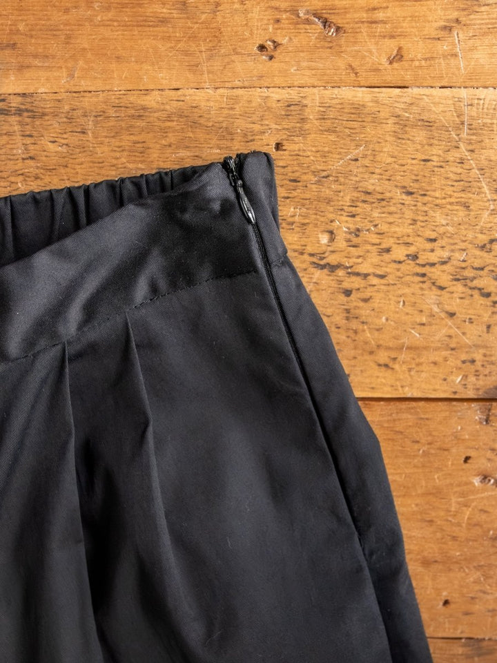 Close-up of The Solvay {Set} high waisted black pants with side zipper and elastic waistband by Savannah Sevens western life{&}style, displayed on a wooden surface.