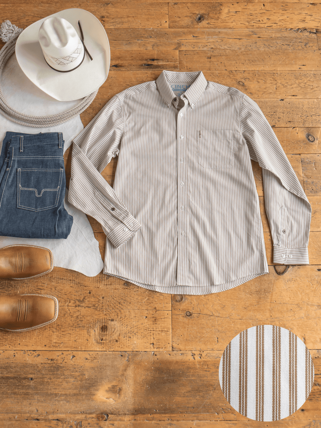 The Steger Cinch Men's White Pinstripe Button Up from Savannah Sevens western life{&}style is displayed on a wooden floor with jeans, a white cowboy hat, coiled rope, and brown boots. An inset showcases the shirt's striped pinstripe fabric.
