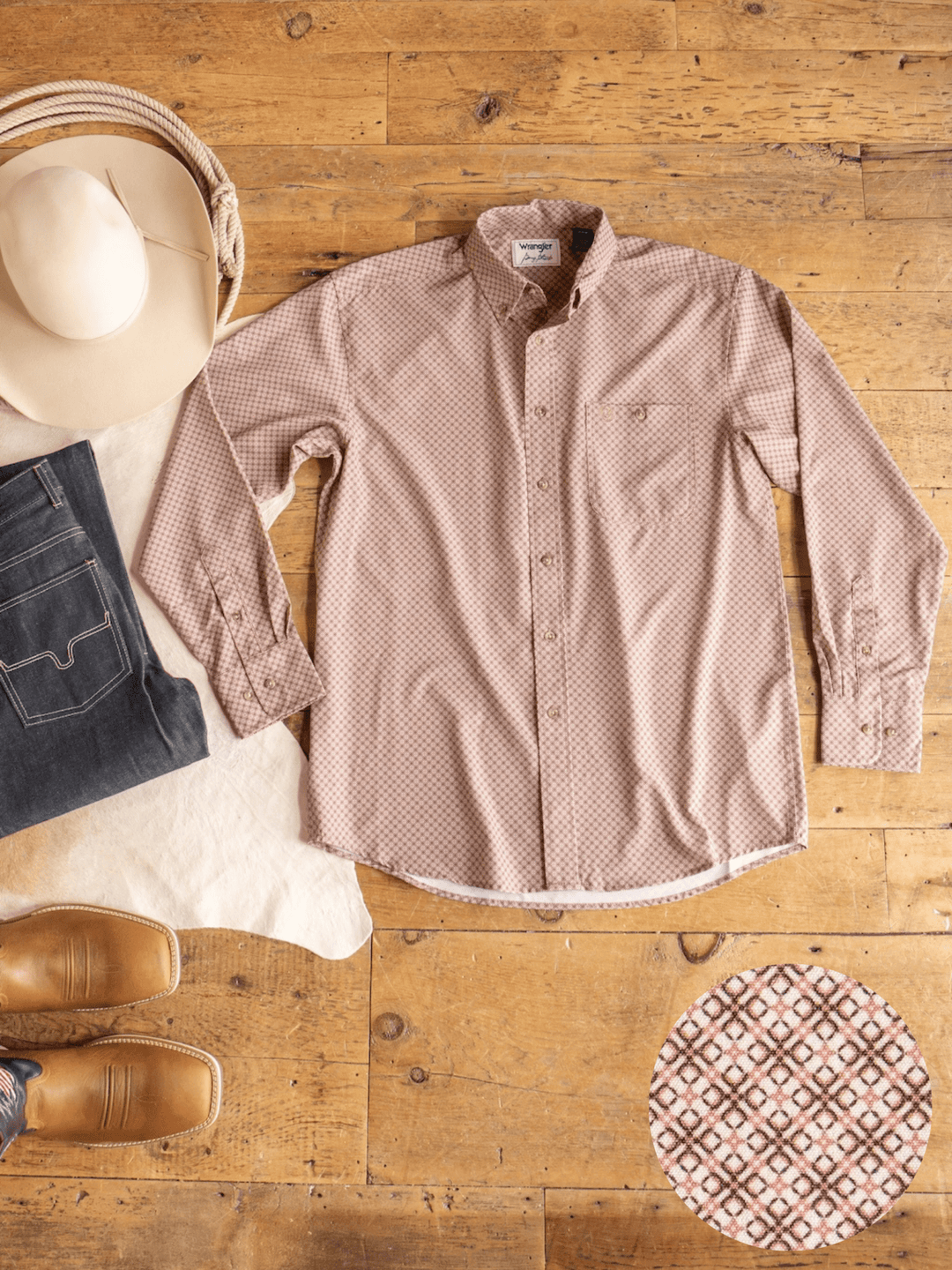 A Strait Wrangler Men's Performance Button Up from Savannah Sevens western life{&}style is displayed on a wooden floor, accompanied by a beige cowboy hat, dark jeans, brown boots, and a close-up highlighting the shirt’s fabric pattern.