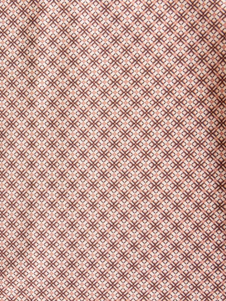A close-up of the fabric from the Strait Wrangler Men's Performance Button Up by Savannah Sevens western life{&}style, featuring a repeating diamond and dot pattern in brown and pink tones that creates a geometric, symmetrical design.