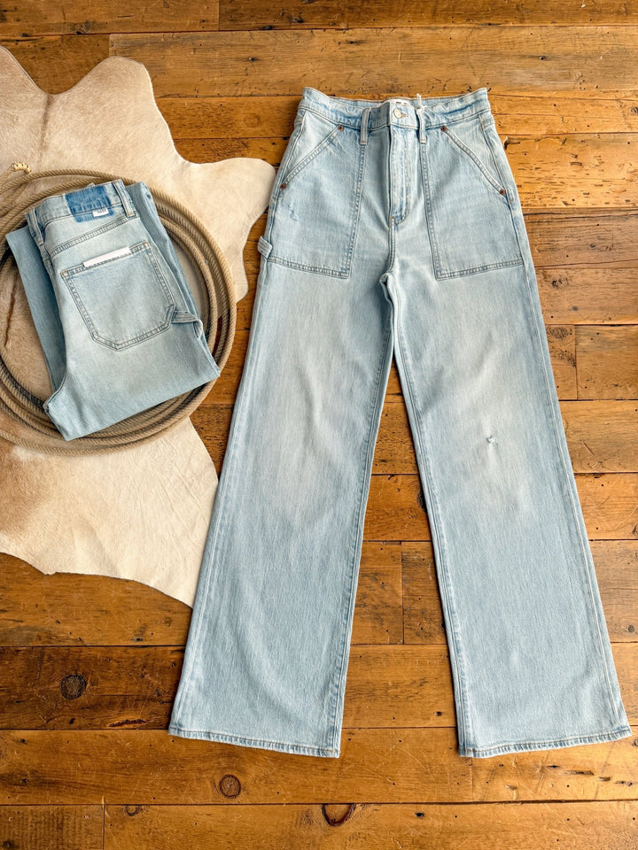 The Tallyn High Rise 90's Wide Leg Jeans by Savannah Sevens western life{&}style are shown in light blue with front patch pockets, laid flat and folded. Both pairs have a relaxed, casual fit in the signature wide leg style.