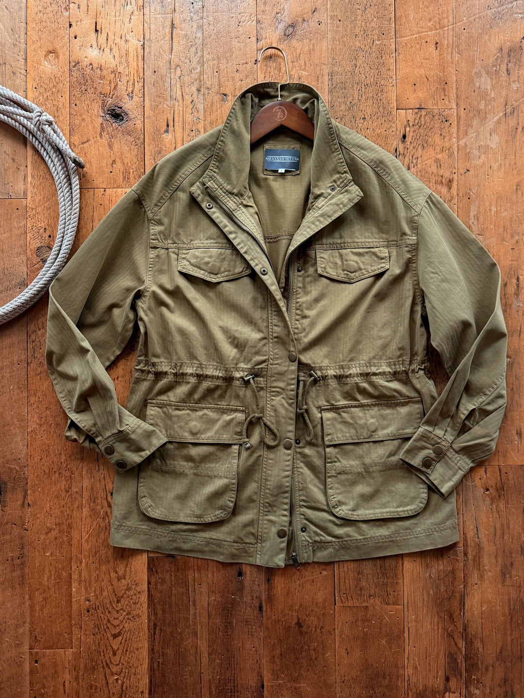 Savannah Sevens western life&style Tamaha Olive Utility Jacket in olive green 100% cotton with a stand collar, snap-button front, four front pockets, and an adjustable cinch waist.