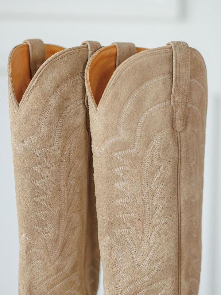 Close-up of The Abby Boot {Driftwood} by Savannah Sevens western life{&}style, featuring premium suede leather, detailed decorative stitching, and pull straps against a soft neutral background. Boots handmade by Tecovas.