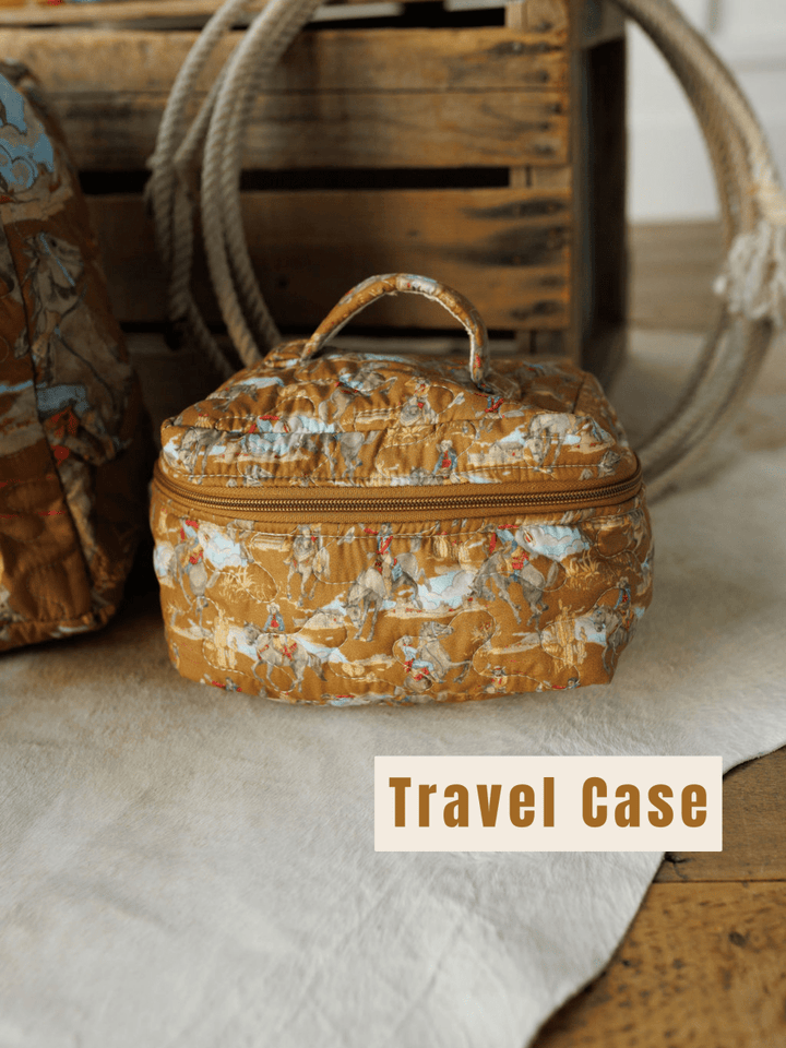 A patterned brown quilted bag set from The Big Sky Collection by Savannah Sevens western life&style rests on a beige rug before a wooden crate, with "Travel Case" in bold at the bottom right.