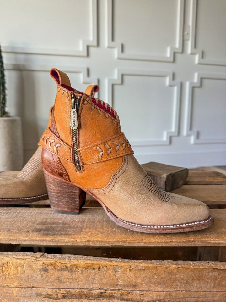 The Cadillacs by Savannah Sevens western life{&}style: Tan and brown leather ankle boots with decorative stitching, side zipper, Goodyear welt construction, and a block heel. Displayed on wood with a white paneled background.